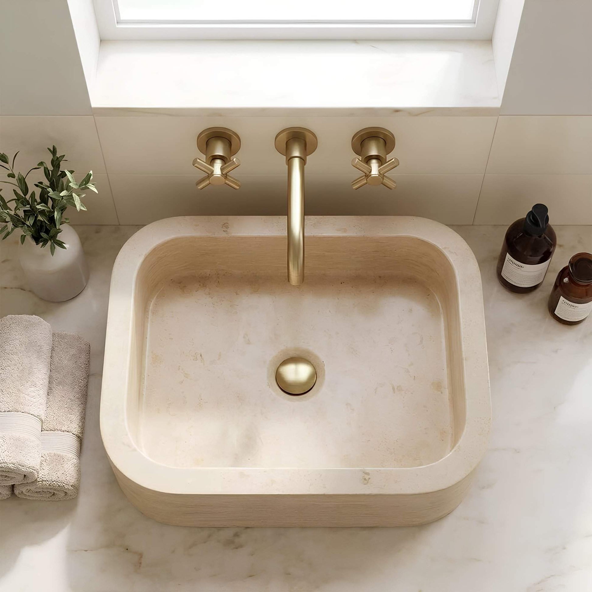 Marble sink with gold faucet in a bathroom setting