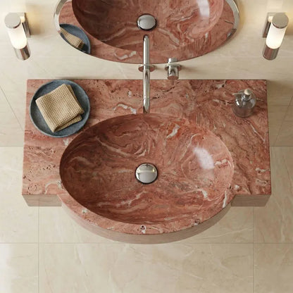 This is not a standard sink. It is a hand-carved red marble oval sink, sculpted from a single block of natural stone and designed as a seamless integrated basin and countertop.