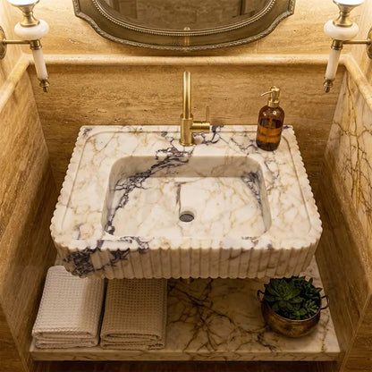Marble sink with gold faucet in a bathroom setting