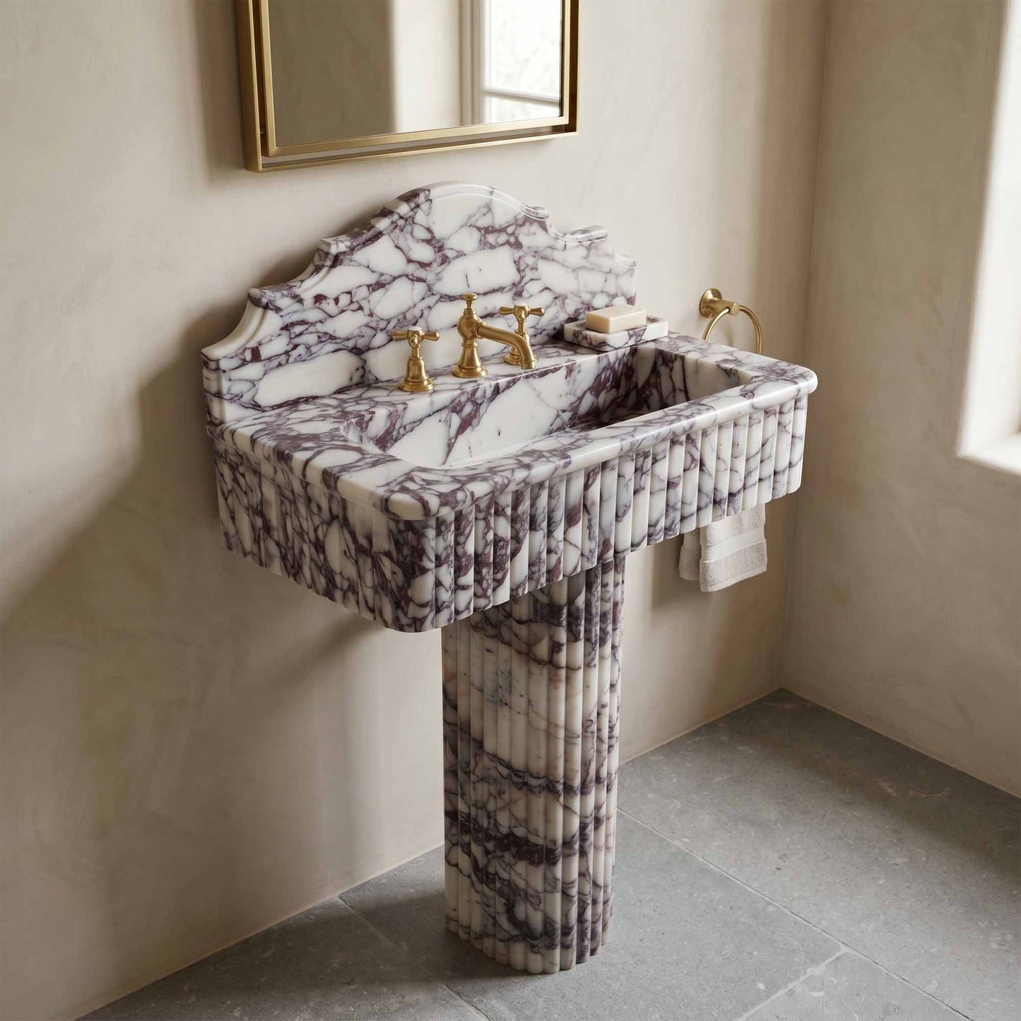 Marble sink with gold fixtures in a bathroom setting