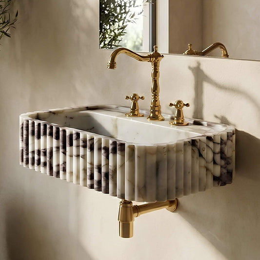 Marble sink with gold fixtures in a bathroom setting