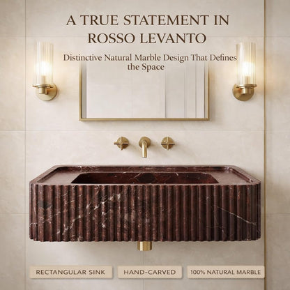 Marble sink with gold fixtures in a bathroom setting, featuring text about Rosso Levanto marble.