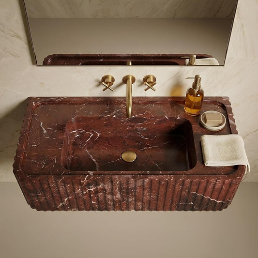 Marble sink with gold fixtures in a bathroom setting