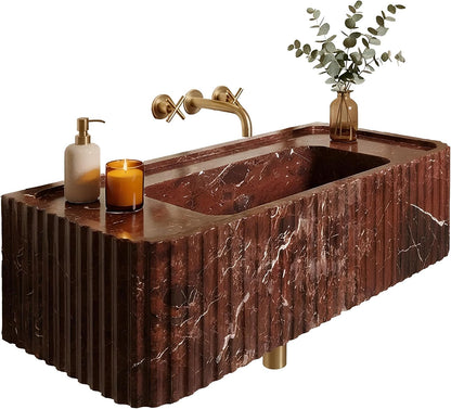 Marble sink with gold fixtures, candle, and plant on a white background