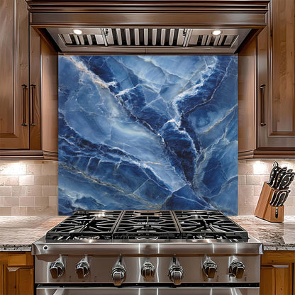 Stainless steel gas stove with blue marble glass backsplash in a kitchen setting