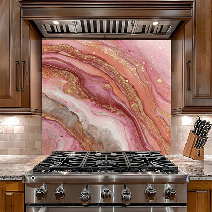 Stainless steel gas stove with pink and gold marbled look glass backsplash in a kitchen setting.