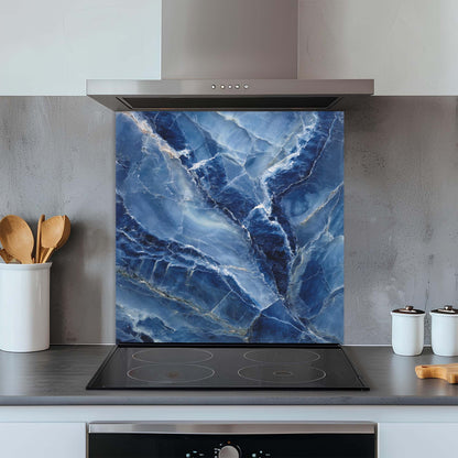 Kitchen with a blue marble glass backsplash behind an electric stove.
