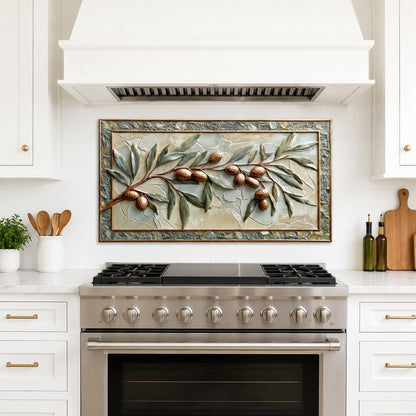 Decorative tile with olive branch design above a stove in a kitchen.