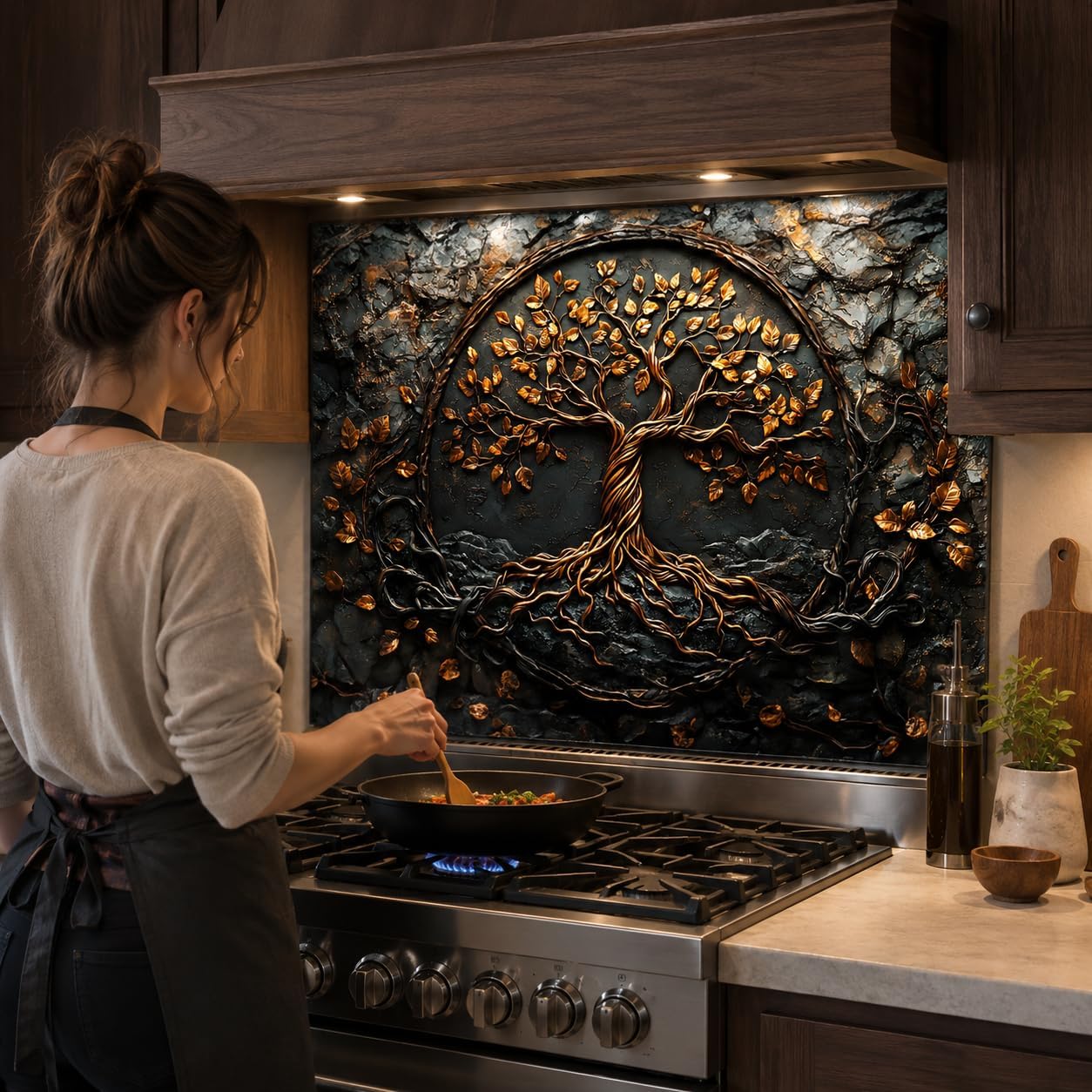 Person cooking in a kitchen with a decorative tree wall art above the stove.