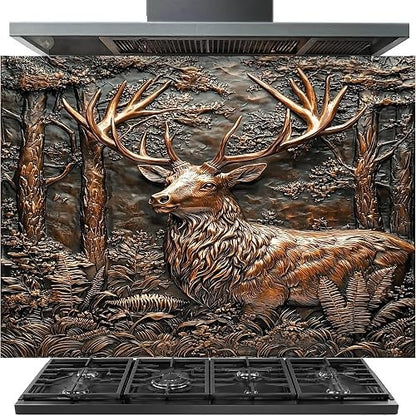 A large decorative backsplash tile featuring a detailed 3D-style relief design of a stag with large antlers standing in a forest, shown installed above a black gas range hood and cooktop.