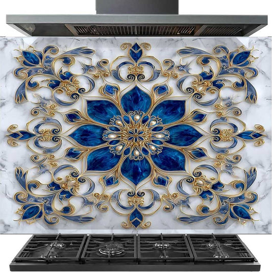 A decorative kitchen backsplash tile featuring an ornate blue and gold mandala design over a white marble background, shown installed above a black gas range.