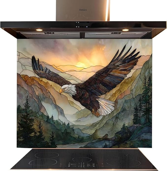 A kitchen backsplash tile featuring a watercolor-style painting of a bald eagle flying over mountains at sunset, installed behind a black induction cooktop and beneath a stainless steel range hood.