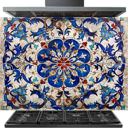 A decorative kitchen backsplash tile panel with a detailed blue, red, and beige floral tile pattern, shown installed behind a black gas range and cooktop.