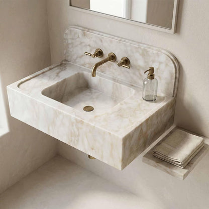 Marble sink with gold faucet and soap dispenser in a bathroom setting