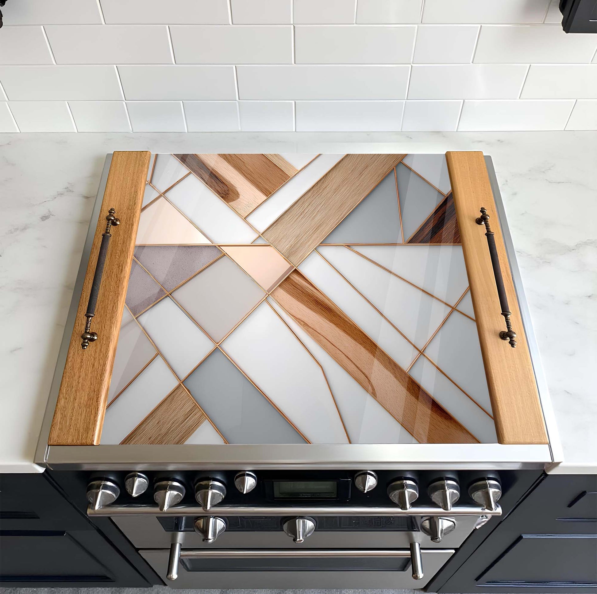 Stainless steel range hood with geometric glass design on a tiled kitchen wall.