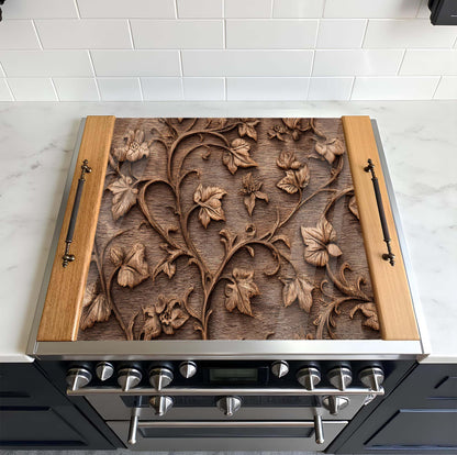 Stainless steel stove with decorative wooden panel featuring floral patterns on a tiled kitchen wall.